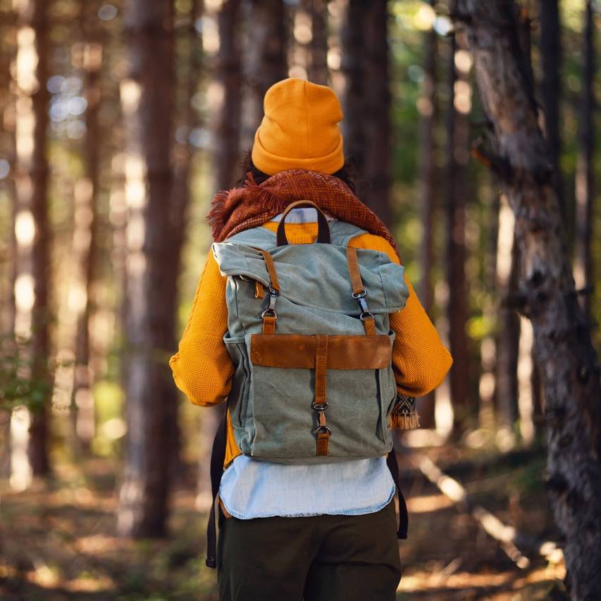 Woman backpacking in forest walking away